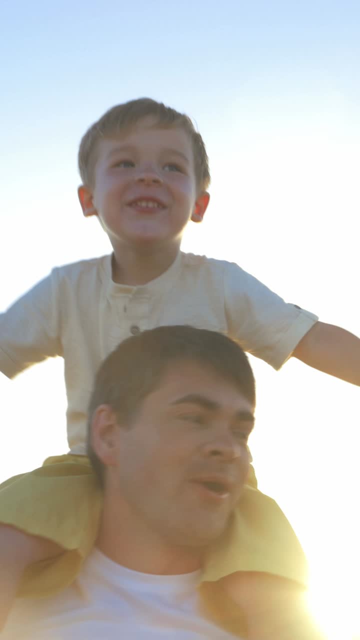 Papà e figlio che si fanno trasportare a cavalluccio