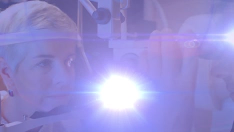 animation of light trails over diverse doctor and patient using slit lamp