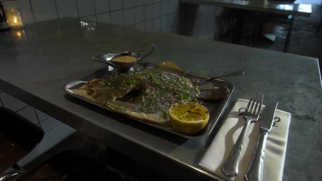 plate with cod is served on a metal table