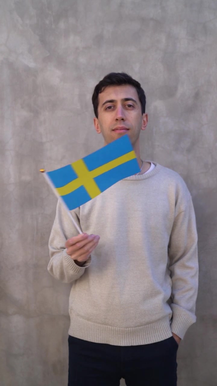Imagem vertical de um homem acenando com a bandeira sueca. Conceito de patriotismo. Câmera lenta
