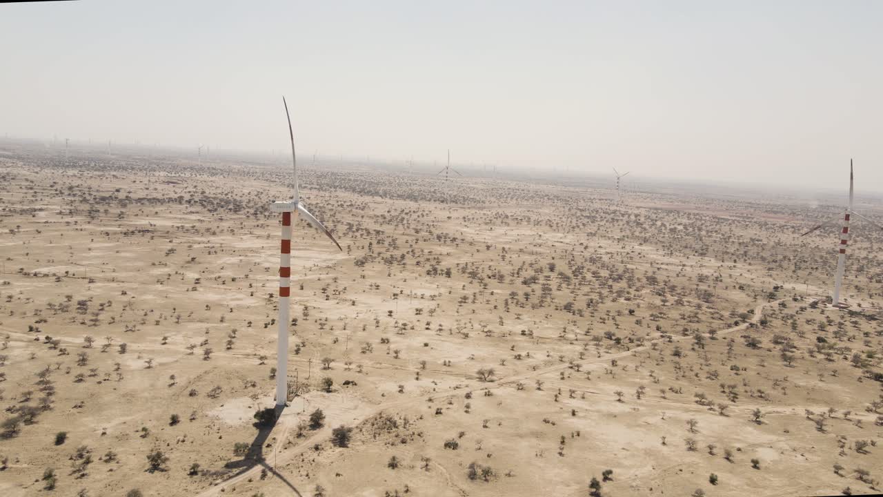 Aerial drone shot revealing windmills dotting the golden landscape of Rajasthan’s wind-blown desert plains.