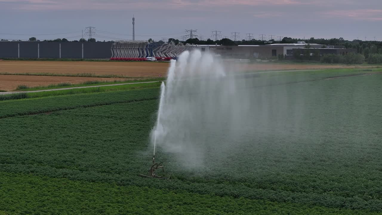 Irrigation system spraying water on a green field