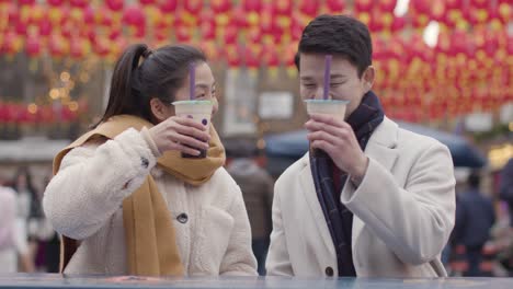 jeune couple asiatique en vacances à boire du thé à bulles dans le quartier chinois de londres uk