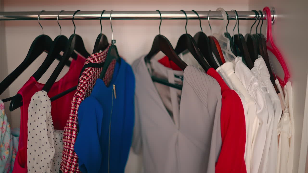 Close-up of Female Hands Plucked Hanger choosing clothes in wardrobe