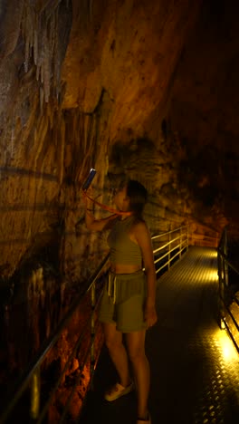 woman exploring a cave with a phone