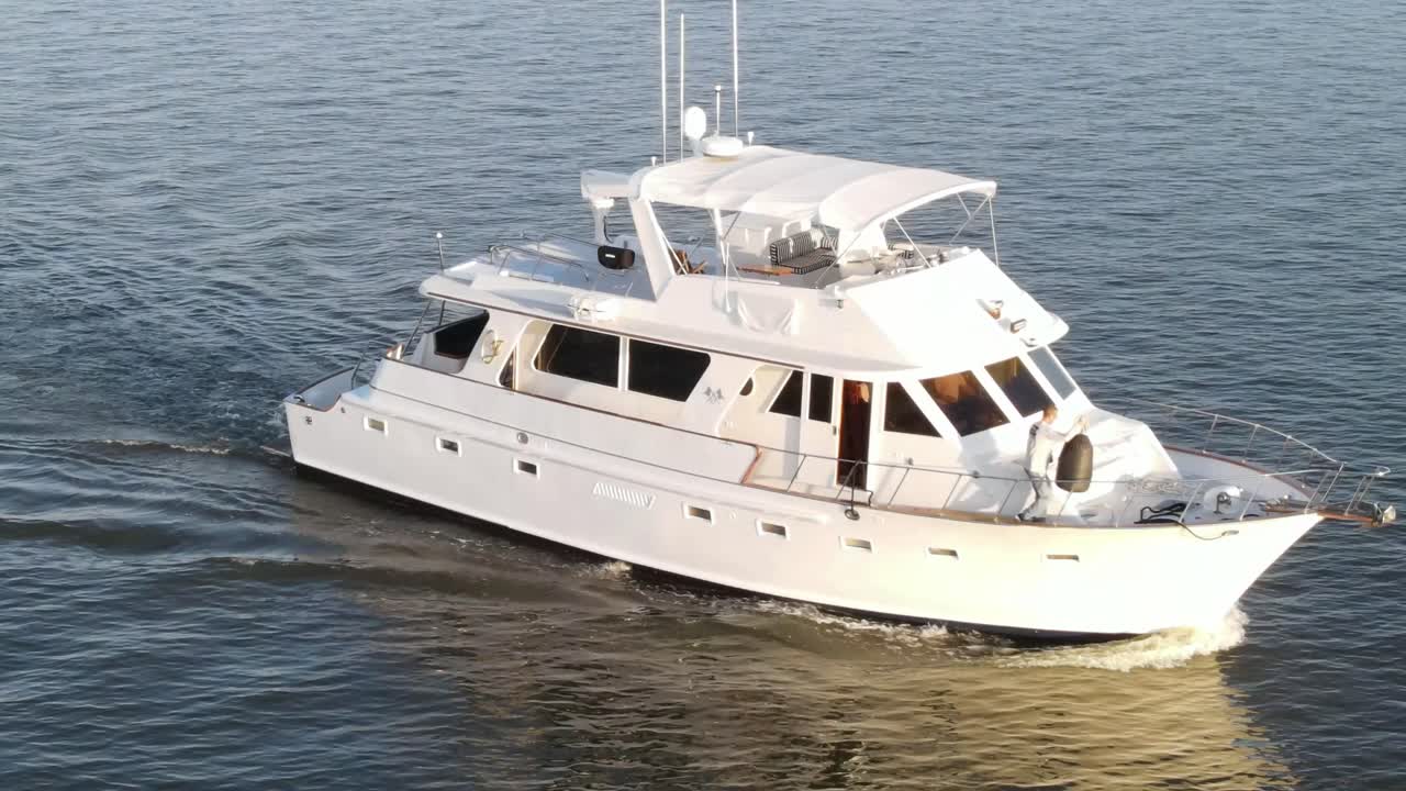 Un marinaio ha spostato una boa nera dall'altra parte, appesa alla ringhiera di uno yacht che naviga nel lago. - aerea