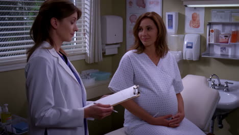 a doctor examines a pregnant woman in a clinic during a prenatal check-up