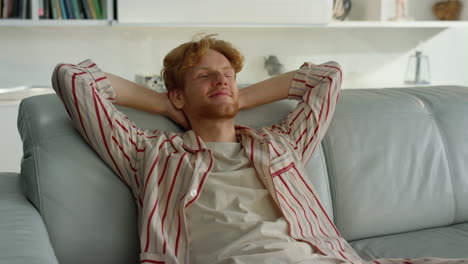 Smiling-guy-lean-couch-at-cozy-home-closeup.-Happy-freelancer-resting-on-couch