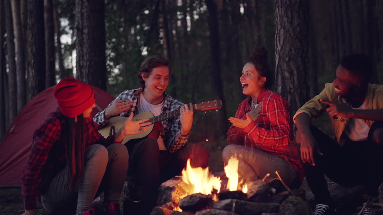 Friends Enjoying Music by Campfire