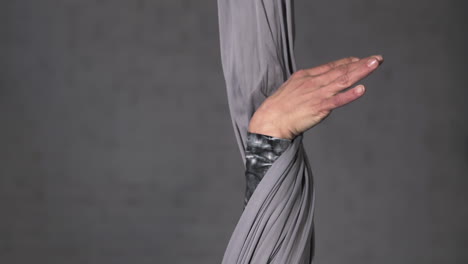 close up slow motion shot of the hands of a circus acrobat letting go of the silk rope after routine