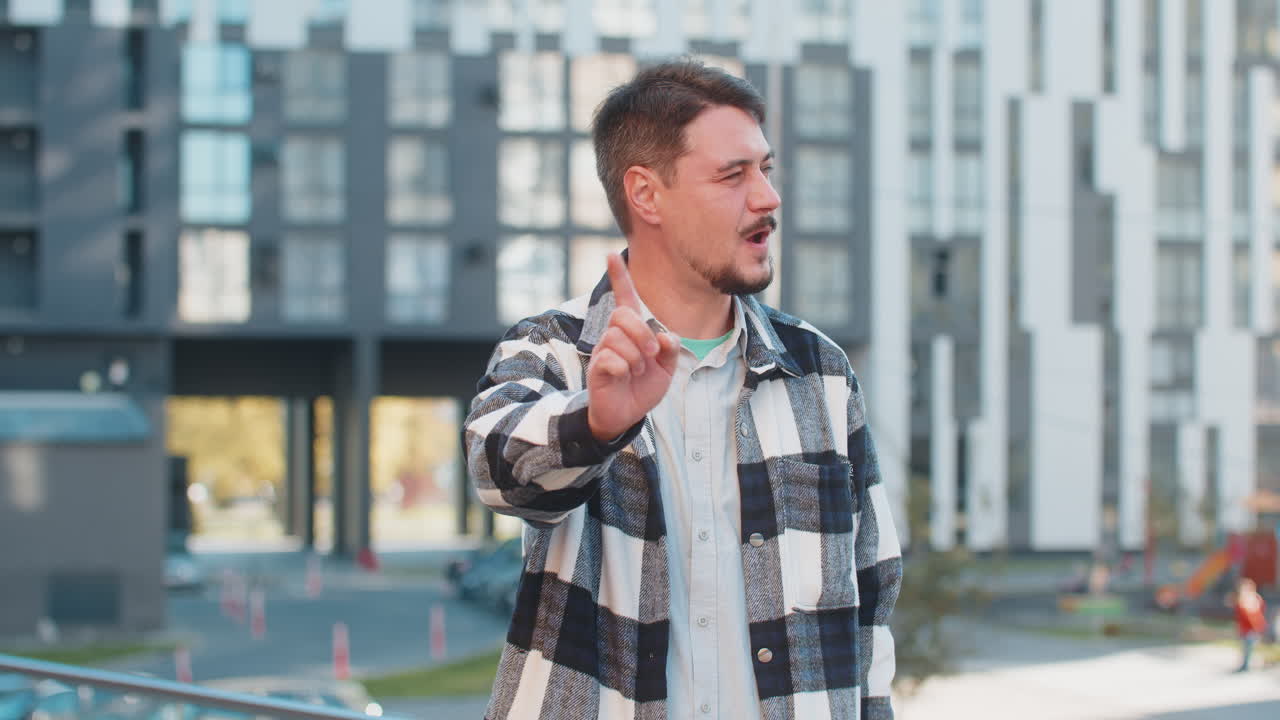 hombre caucásico molesto reaccionando a una desagradable idea horrible sacudiendo el dedo a la cámara en la calle urbana de la ciudad