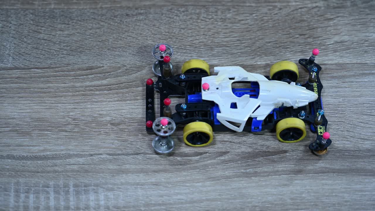 태국 방 ⁇  의 한 가게 에서 바 ⁇  의 균형 과 정렬 을 확인 하기 위해 타미야 미니 스포츠 자동차 를 앞뒤 로 밀고 끌고 있는 모습