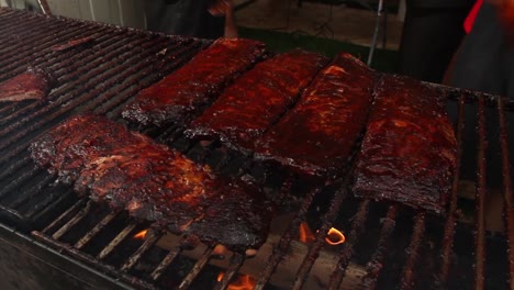 Barbecue-sauce-being-applied-on-racks-of-ribs