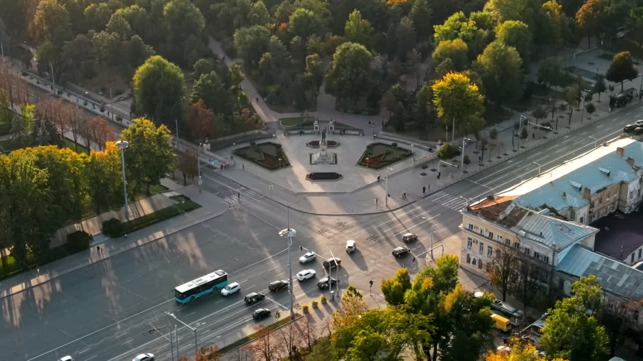 Aerial drone view of Chisinau downtown at sunset. View of central park, Stephen the Great monument, a lot of greenery, roads with cars. Moldova