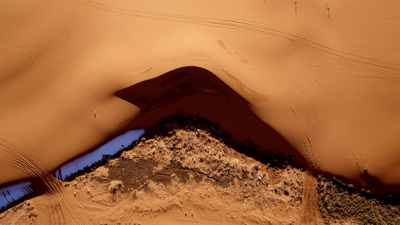 Aerial drone shot reveals the striking pink sand dunes and their intriguing landscape.