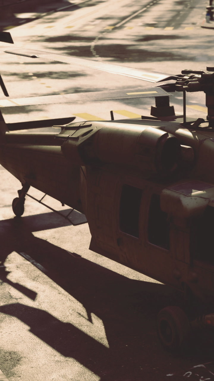 Military helicopter prepares for takeoff at a sunny airfield in the afternoon