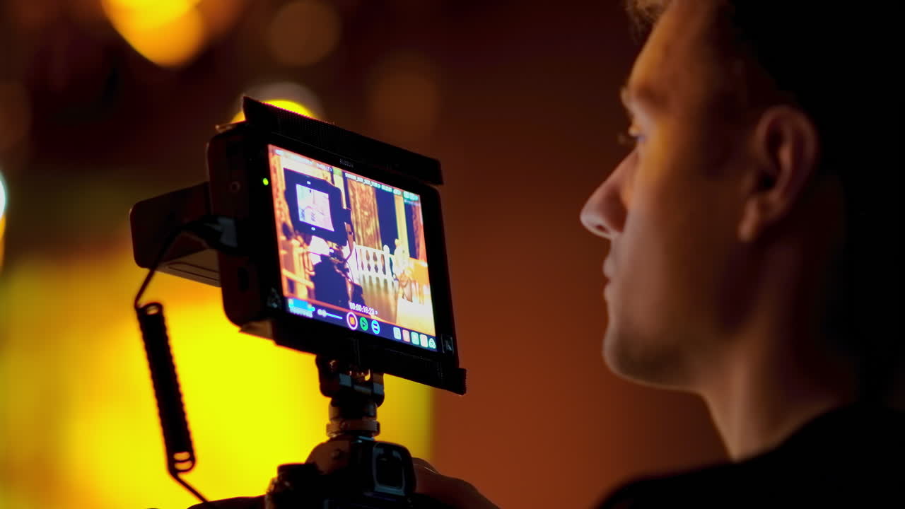 Man filming with professional camera on the backstage of a TV set