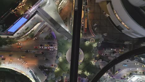 aerial night view of a busy city intersection with traffic and elevated train tracks