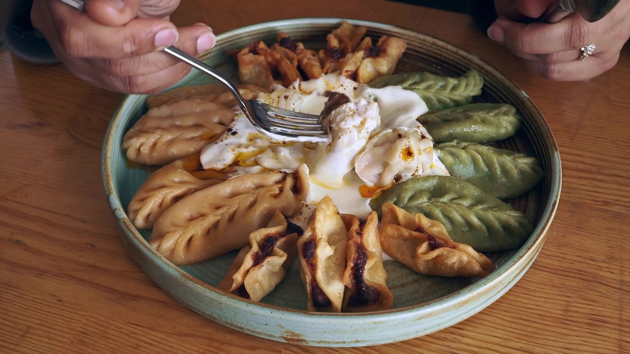 Seseorang Makan Pangsit Tradisional dengan Saus Yogurt