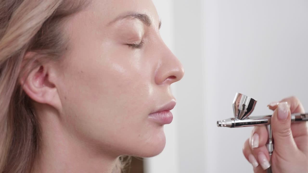 Woman receiving airbrush makeup application