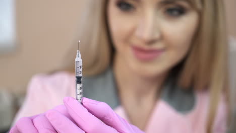 Doctor in a dressing gown and gloves, preparing an injection syringe.