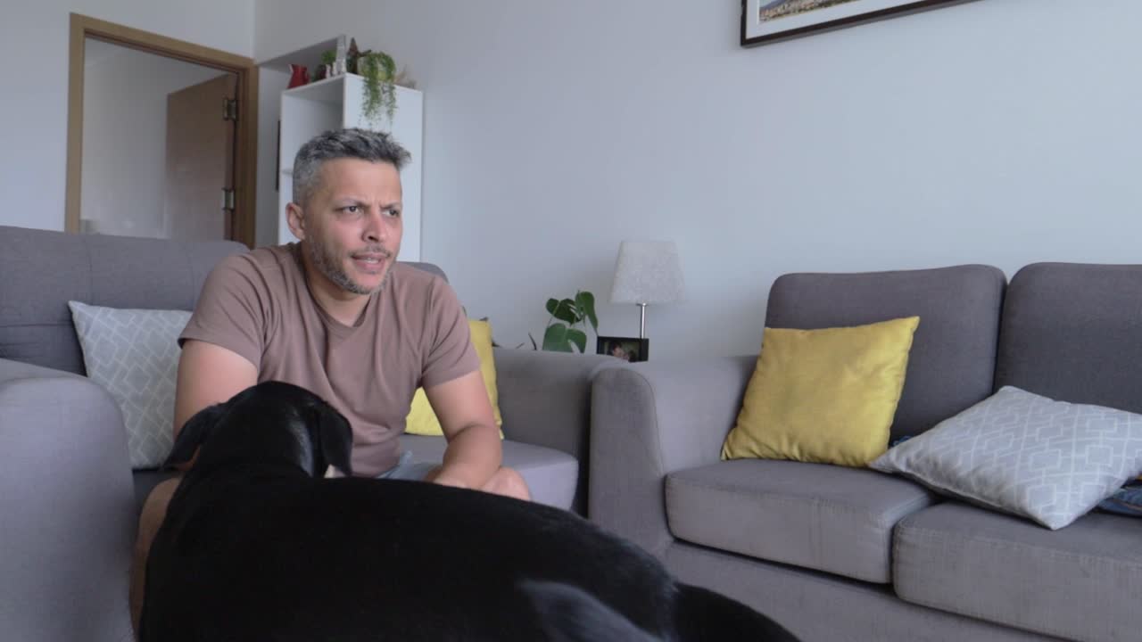 Man Struggles with Dumbbell Exercise and Pets His Dog