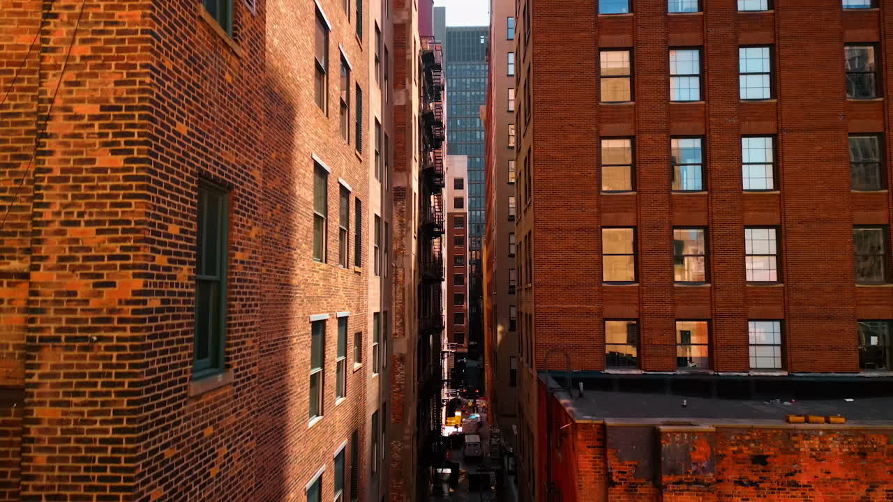 Detroit, USA, 28 July 2025: Rising along the multi-storied red brick buildings of old style with outside fire escape stairs. Revealing view on the marrow street among the rear facades of the high-rises. Detroit, Michigan, USA