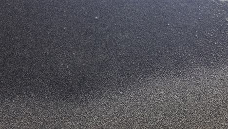 abstract close-up of black sand and seafoam