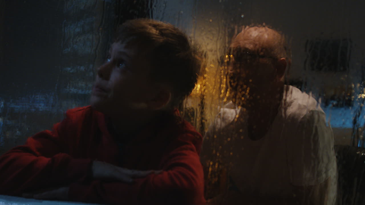 Grandson and Grandfather Watching the Rain