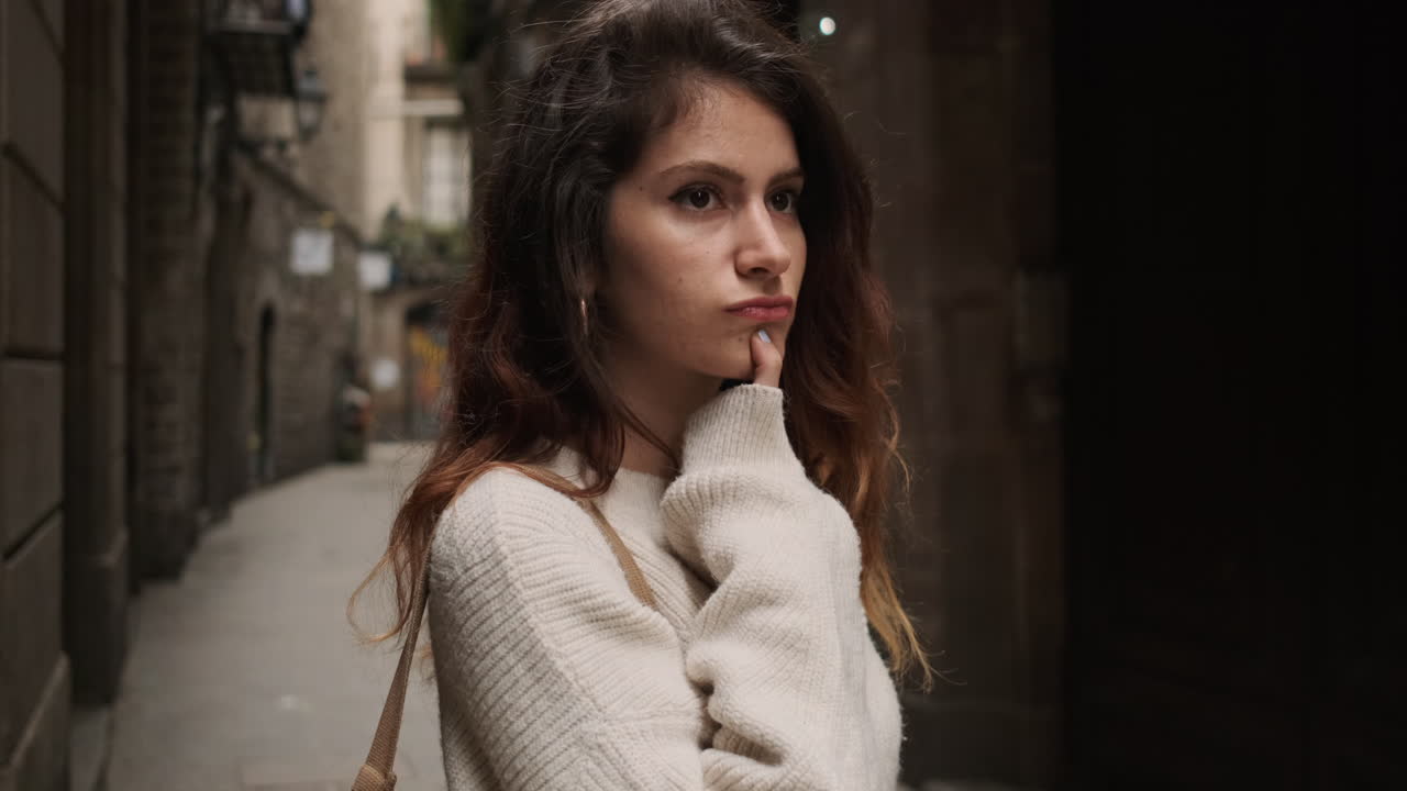 mujer pensativa en una calle estrecha