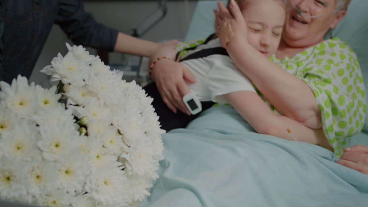 Close up of niece hugging aged woman at family visit in hospital ward