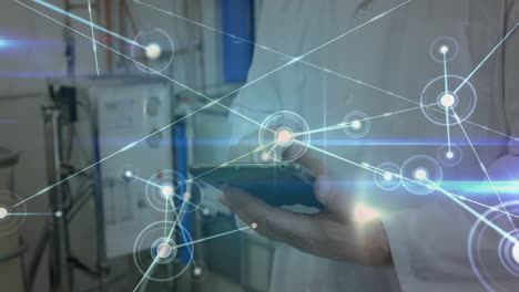 male technician holding tablet in factory, showing glowing network nodes and connecting lines