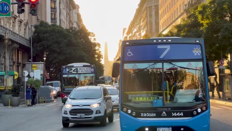 buses and traffic on a bustling city street during sunset or sunrise in buenos aires