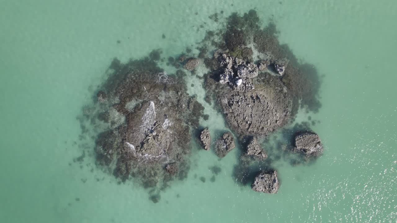 vista superior de olas tranquilas sobre afloramientos en el océano prístino