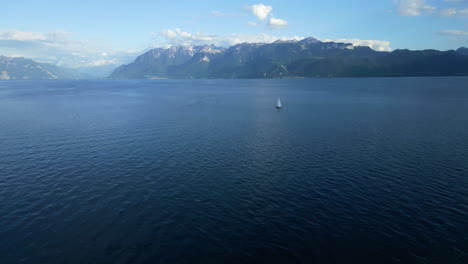 aerial: boat sailing on lake geneva during the day near lavaux, canton of vaud, switzerland, reveal drone shot
