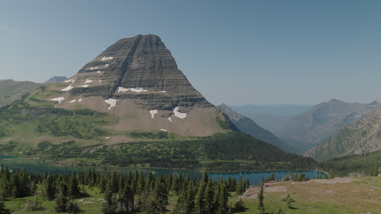 Scenic view of Logan Pass in Montana, showcasing towering mountains and tranquil lake