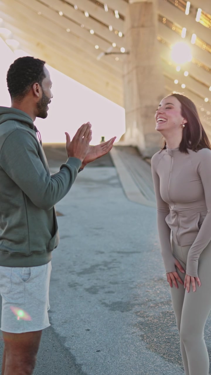 Young Couple Talking and Laughing Outdoors in Sportswear