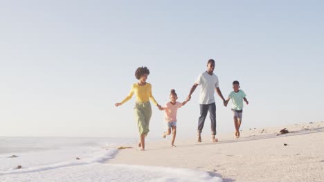 Lächelnde-Afroamerikanische-Familie,-Die-Am-Sonnigen-Strand-Händchen-Hält