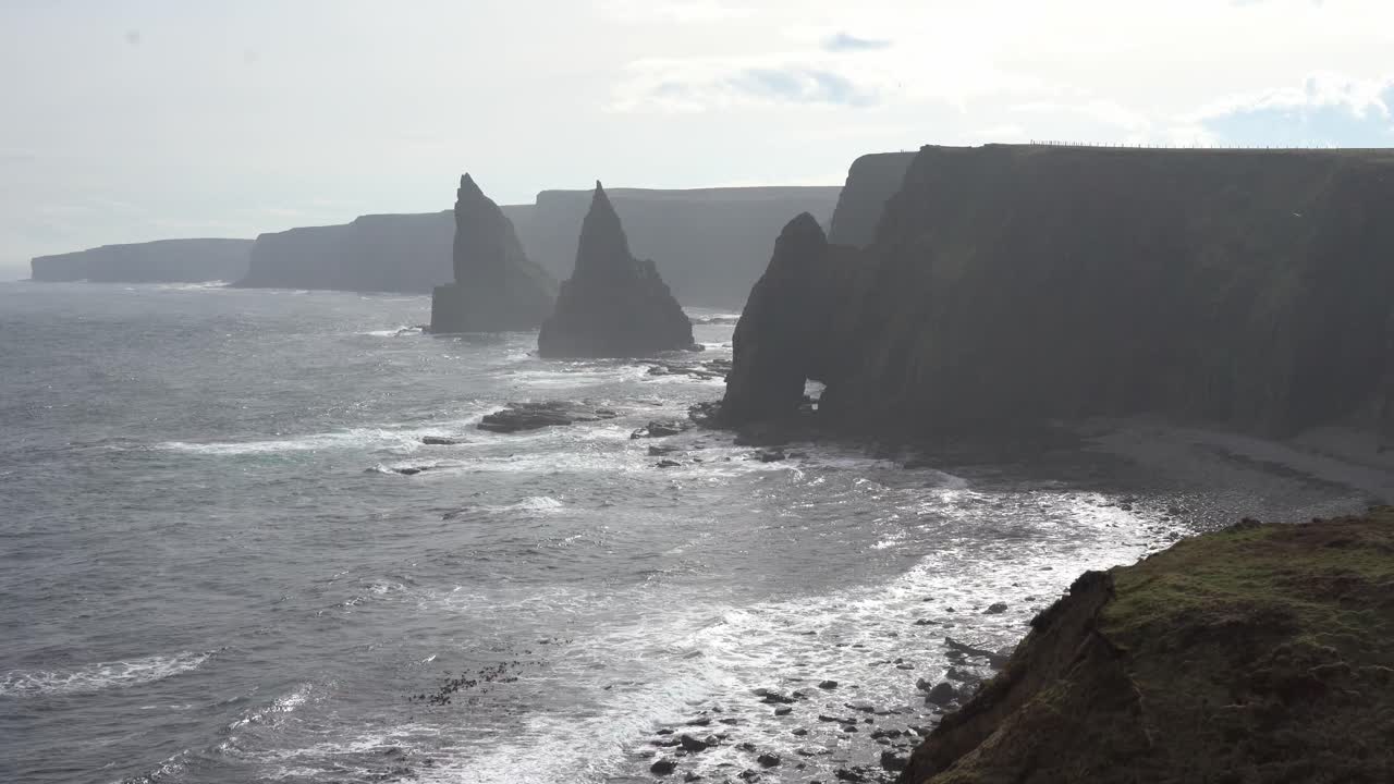 Handheld scene showing off the rough ocean around Duncansby Stacks in Scotland with birds and waves
