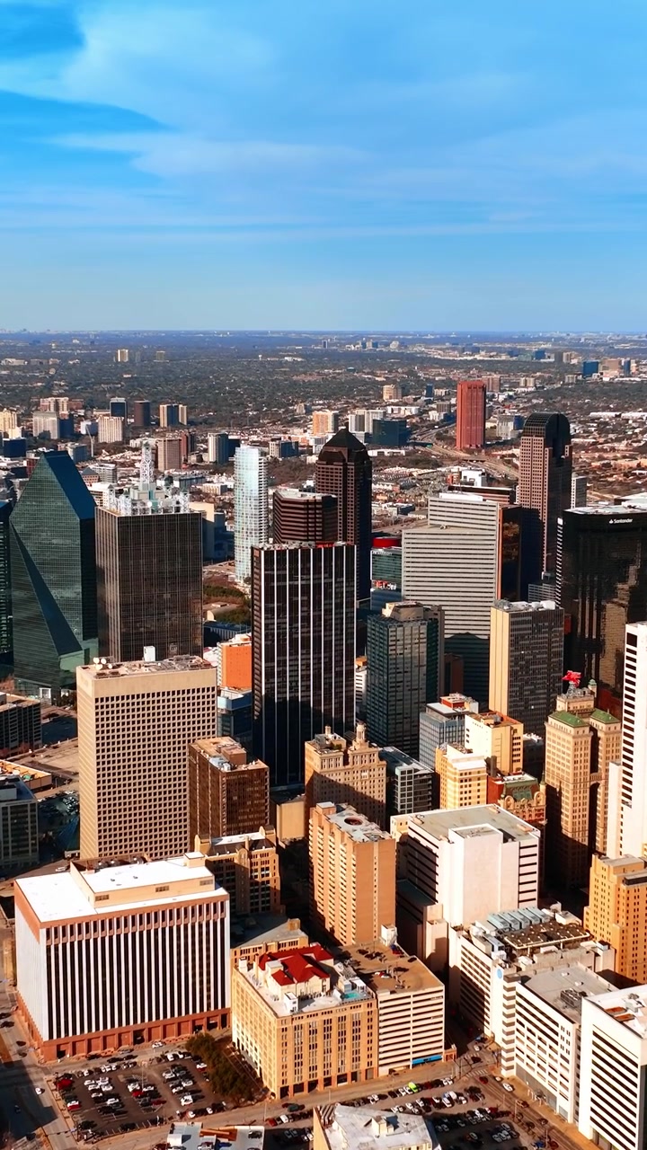 Avvicinandosi al moderno centro di Dallas, Texas, con maestosi grattacieli. Scenario soleggiato della metropoli ripreso da drone. Video verticale.