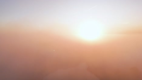 ethereal sunrise or sunset above a foggy landscape with trees