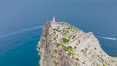 Breathtaking-aerial-approach-toward-lighthouse-on-cliff-edge,-Mallorca