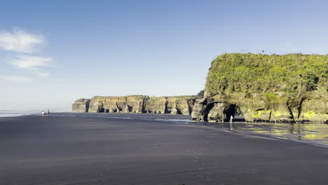 turistas en la famosa playa de tres hermanas y la roca elefante cerca de tongaporutu, región de taranaki en nueva zelanda