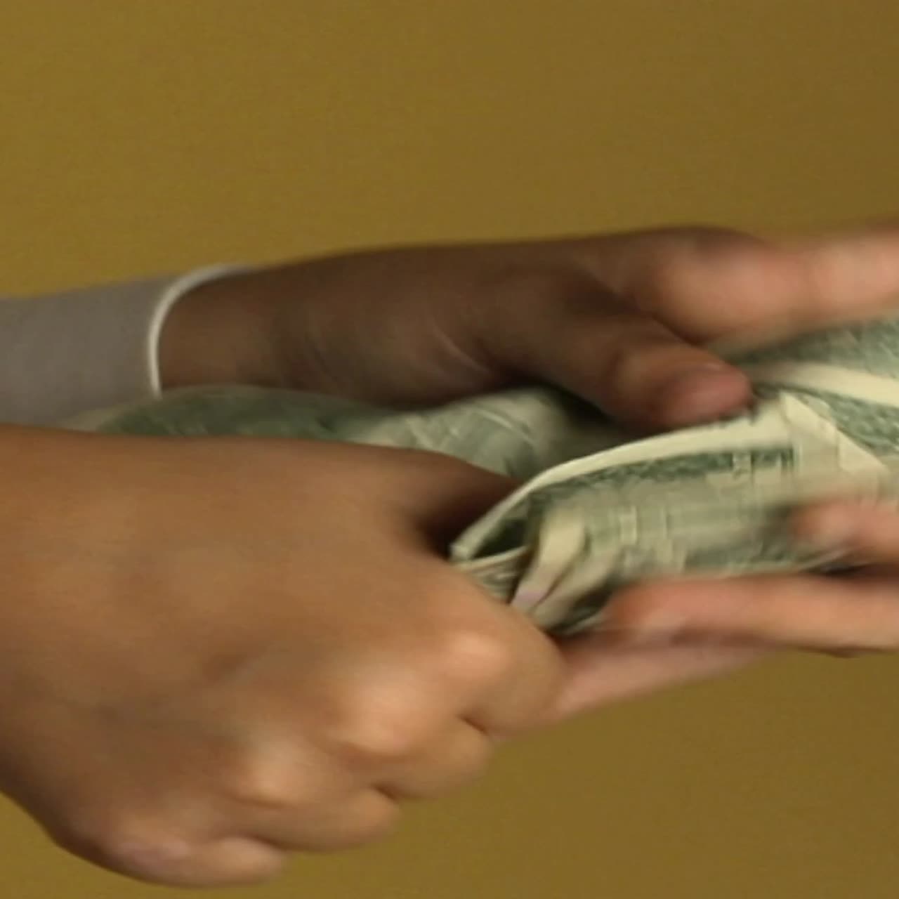 Een vrouw betaalt iemand met een stapel dollarbiljetten