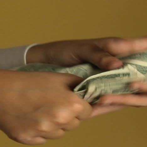 a woman pays a person with a stack of dollar bills