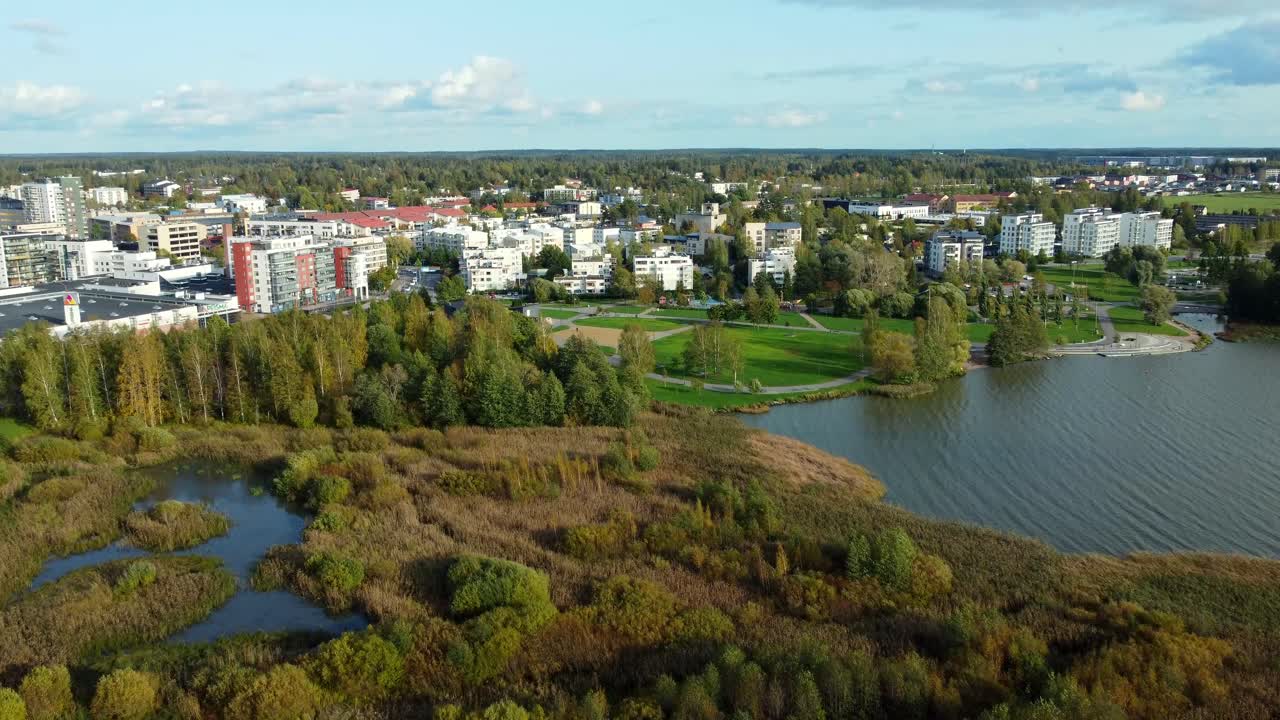 Fly over a wetland in the city of J&auml;rvenp&auml;&auml;, rural skyline on a sunny and calm day surrounded by a pine forest, sustained and environmentally friendly growth