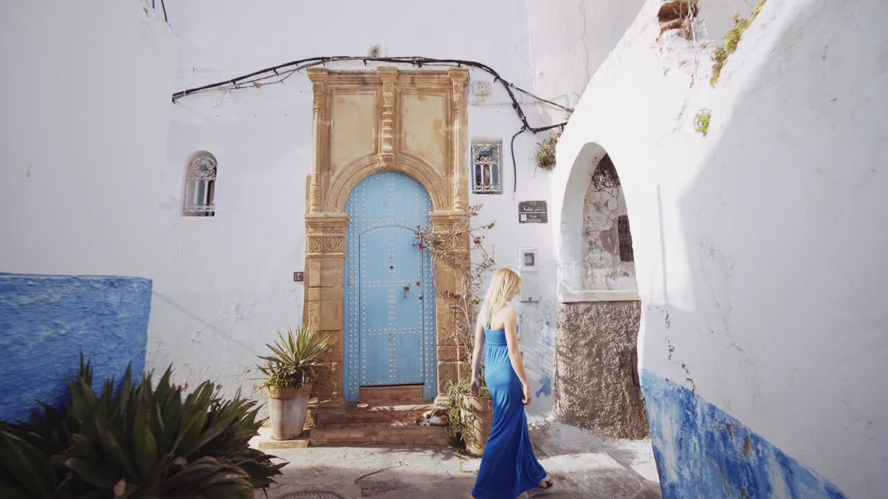 mujer rubia en vestido azul en la kasbah de los udayas