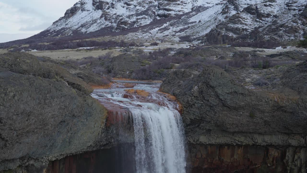 Amazing Salto del Agrio waterfall plunging into a rocky Patagonian canyon with aqueous mist rising, Neuquén, Argentina