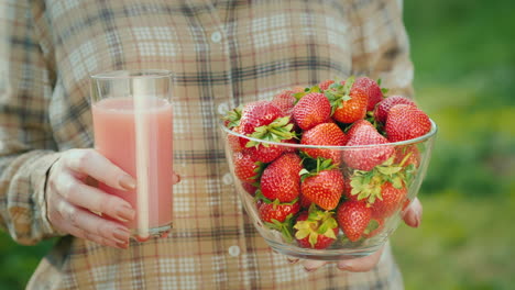 Eine-Frau-Hält-Ein-Glas-Knollen-Und-Eine-Schüssel-Erdbeerbeeren