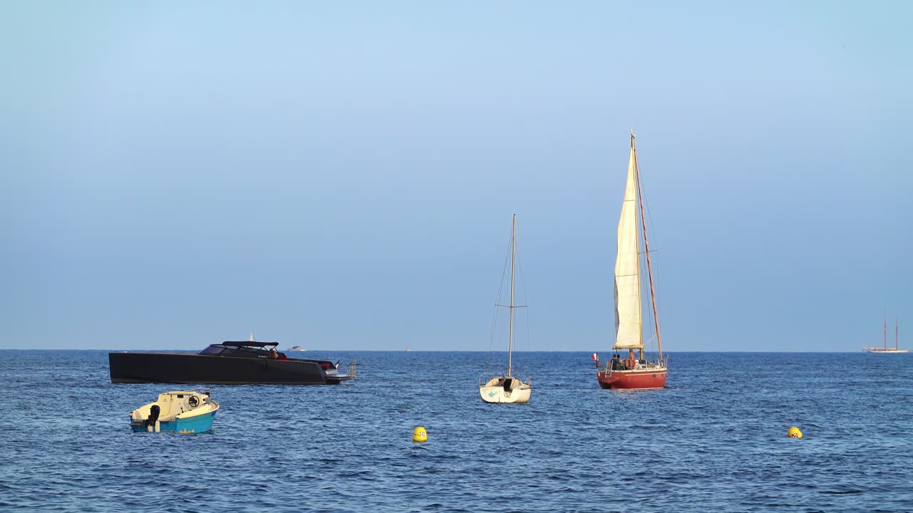 People on moving, orange and black boats on the sea in France